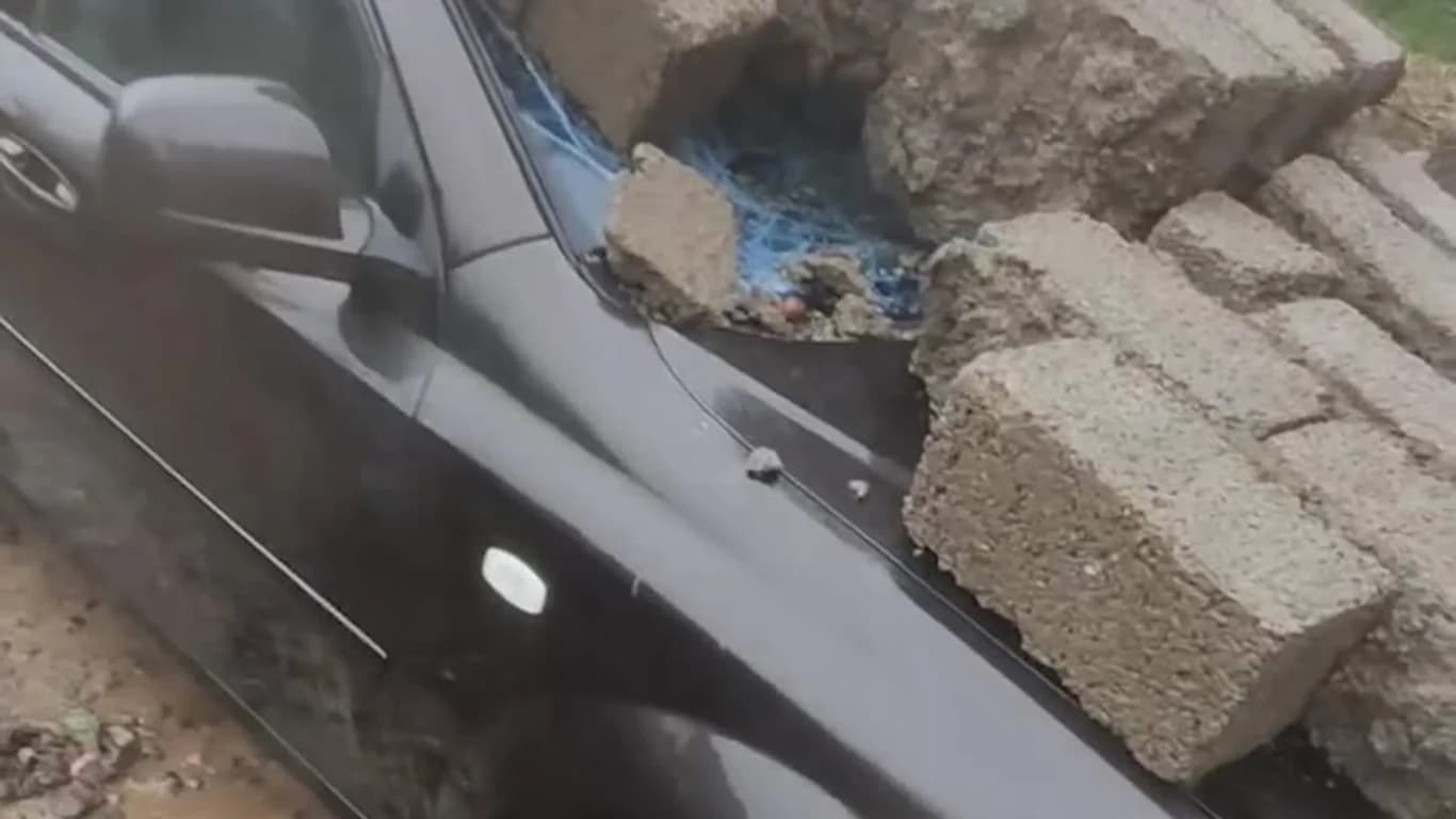 Wall collapses onto car following heavy downpour