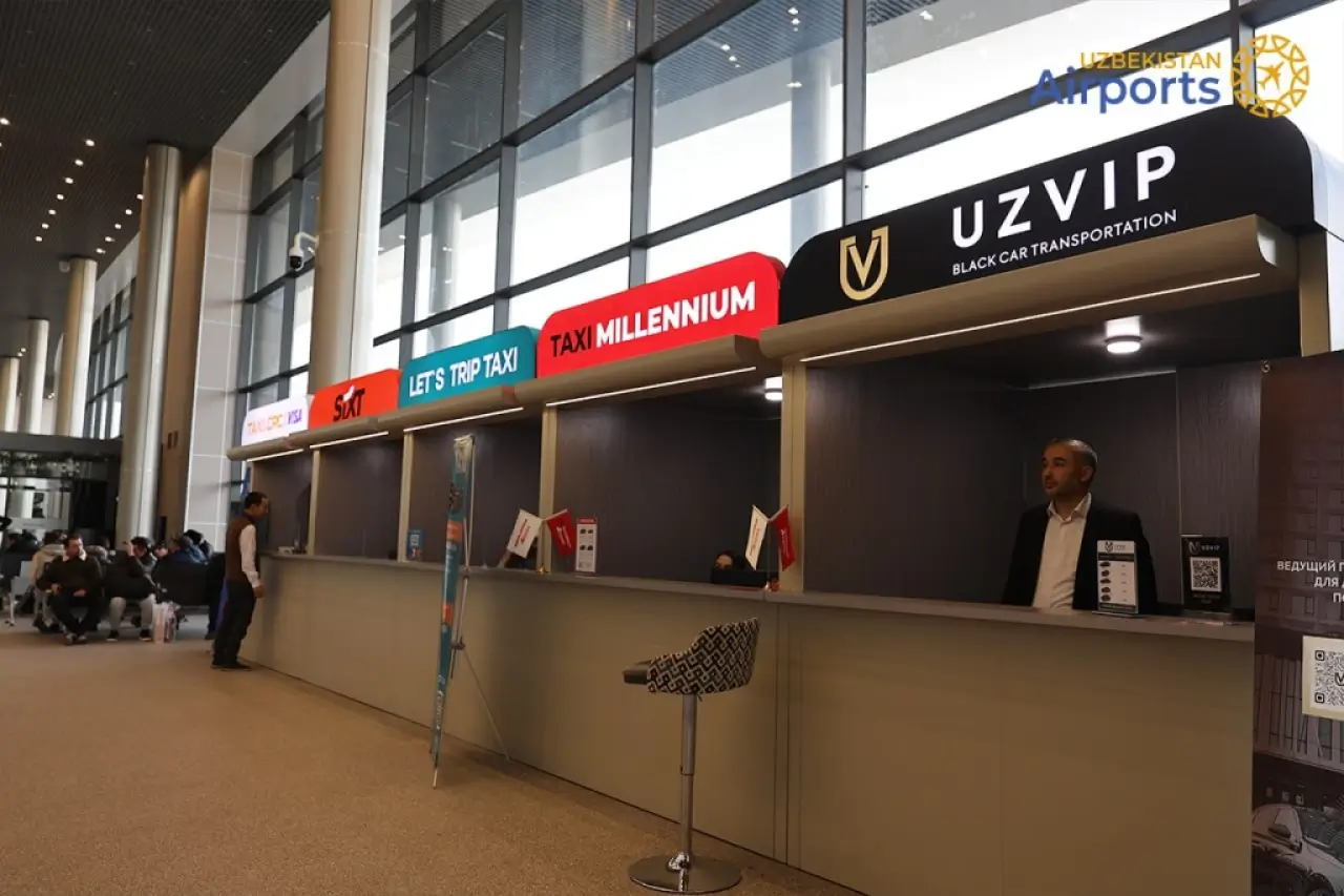 Toshkent aeroportida terminal chiqishida taksi Rasmiy tashuvchilar yo‘lovchini kelish zonasida terminal yonidan olib ketadi