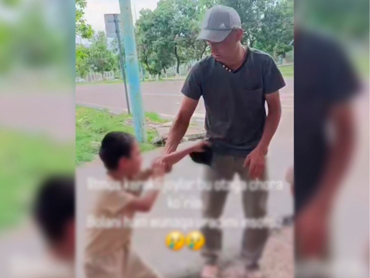 Kepka kiygan erkak kichik bolaning qo‘lidan ushlab turibdi.