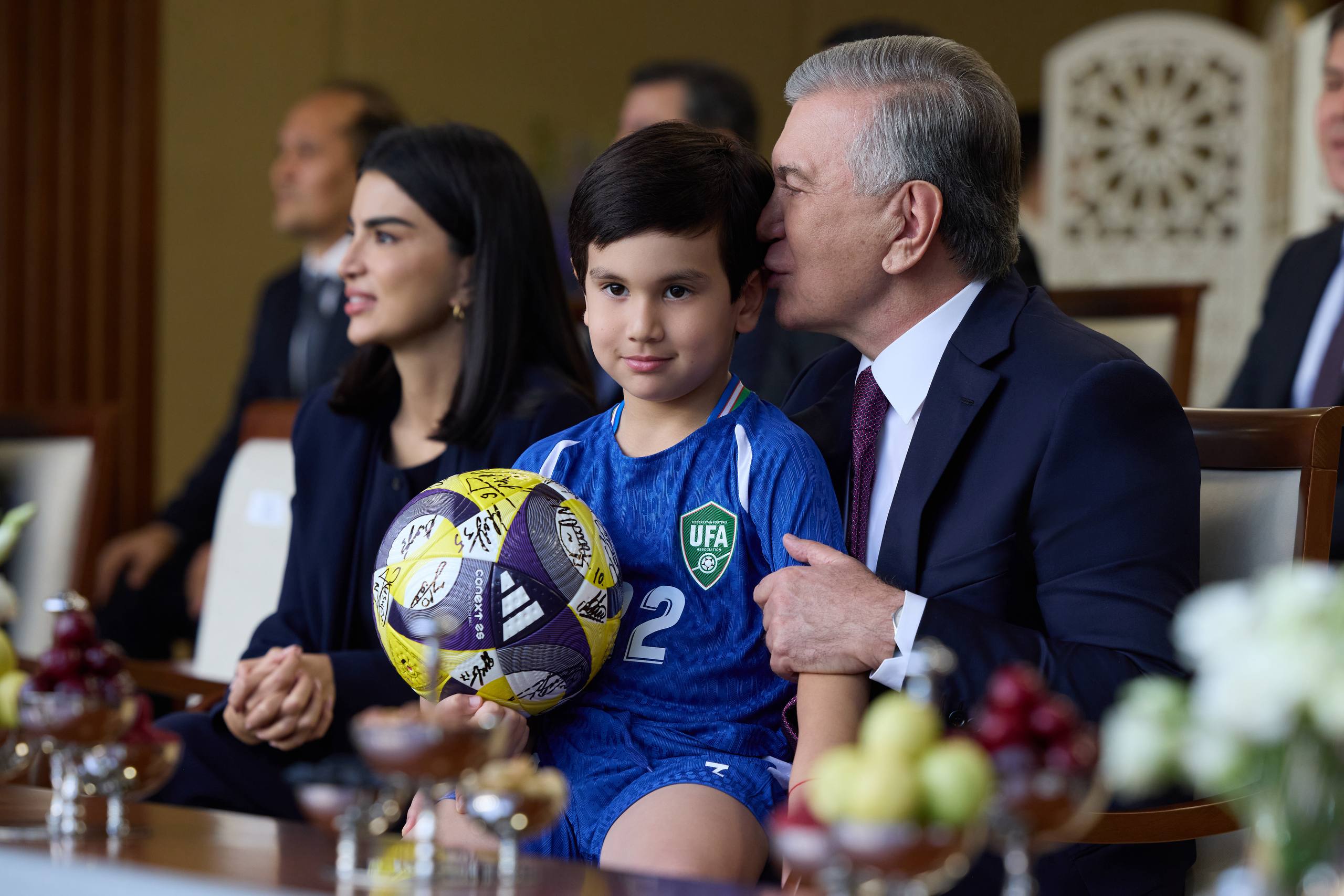 Prezident Shavkat Mirziyoyev futbol to‘pini ushlab turgan bolani bag‘riga bosmoqda.