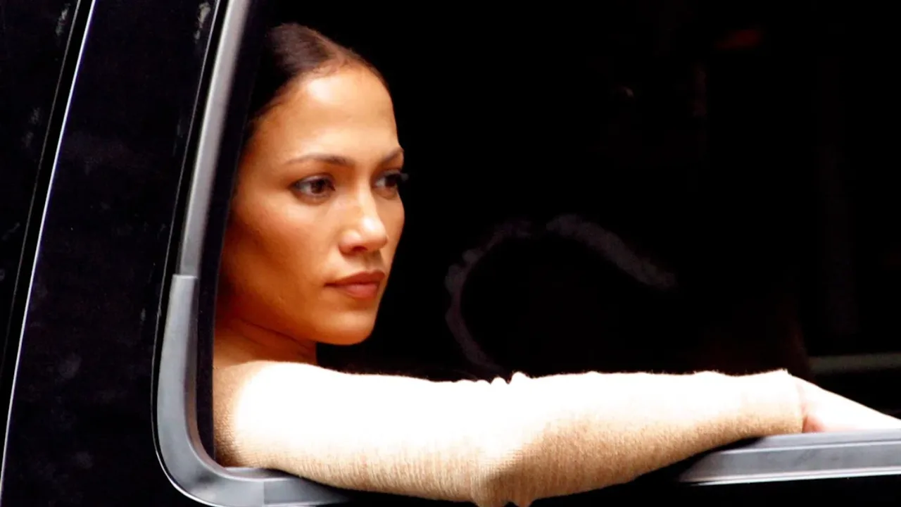 Jennifer Lopez qora rangli mashina derazasidan tashqariga qarab turibdi.