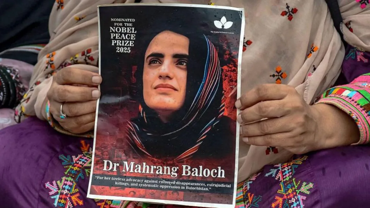 Ayol kishi qoʻlida doktor Mahrang Baloch tasvirlangan plakatni ushlab turibdi.