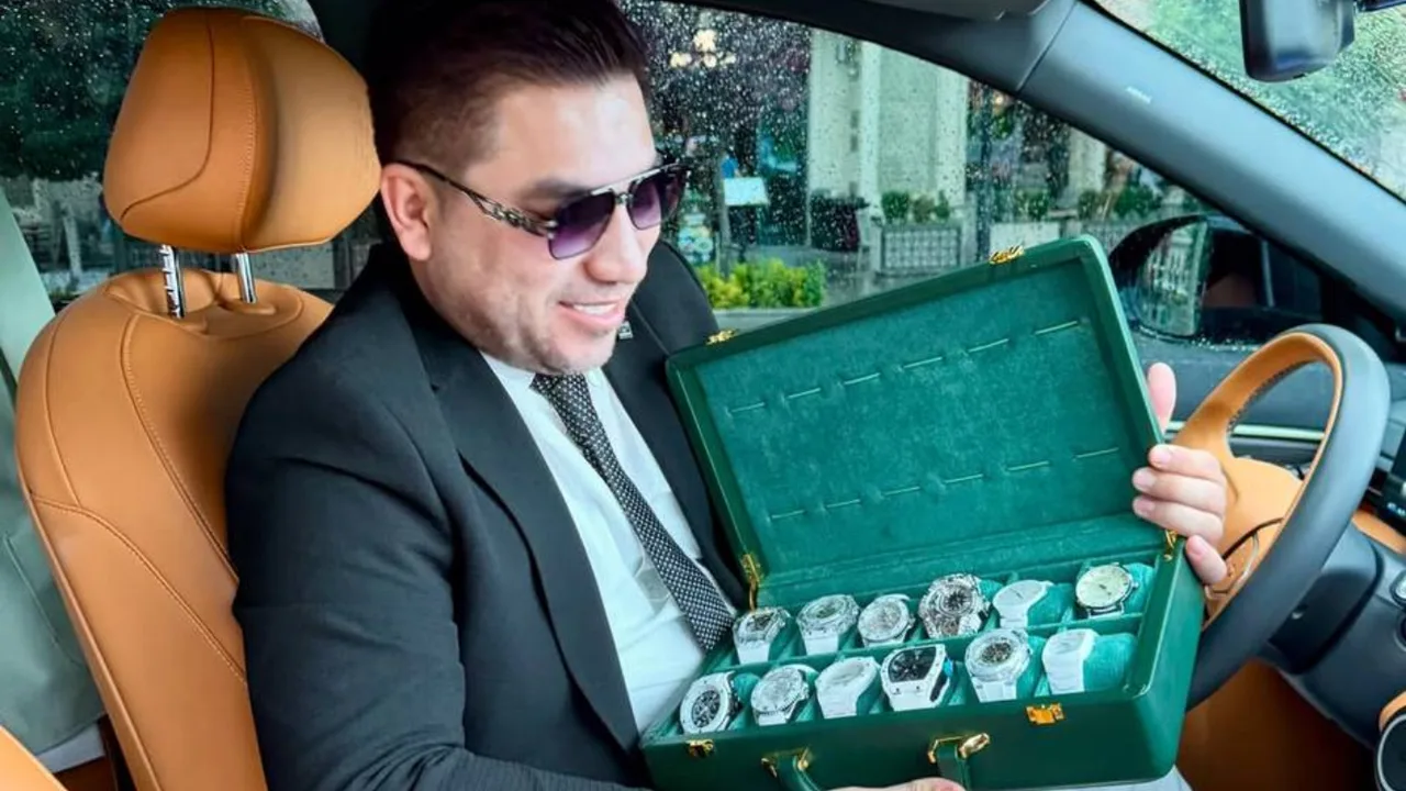 Kostyum kiygan erkak mashina ichida yashil qutidagi qimmatbaho soatlar to‘plamini ushlab turibdi.