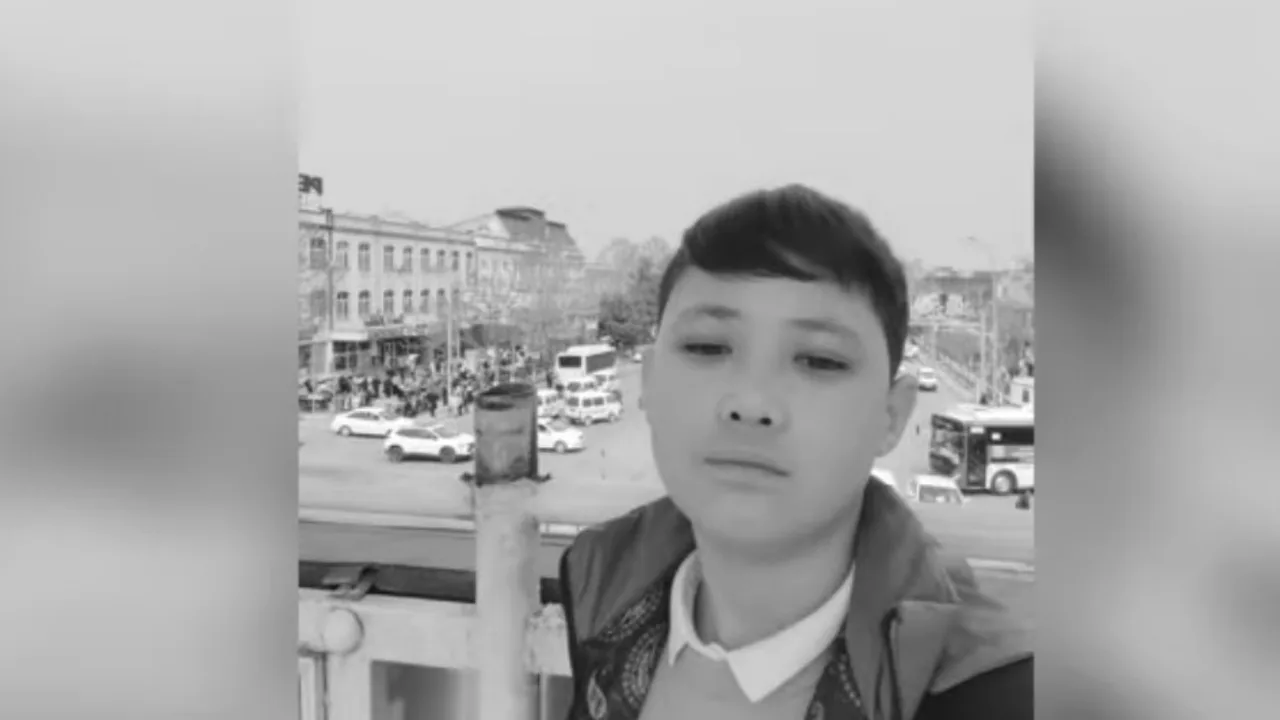 Shahar ko'chasida turgan o'smir yigitning oq-qora selfi surati.