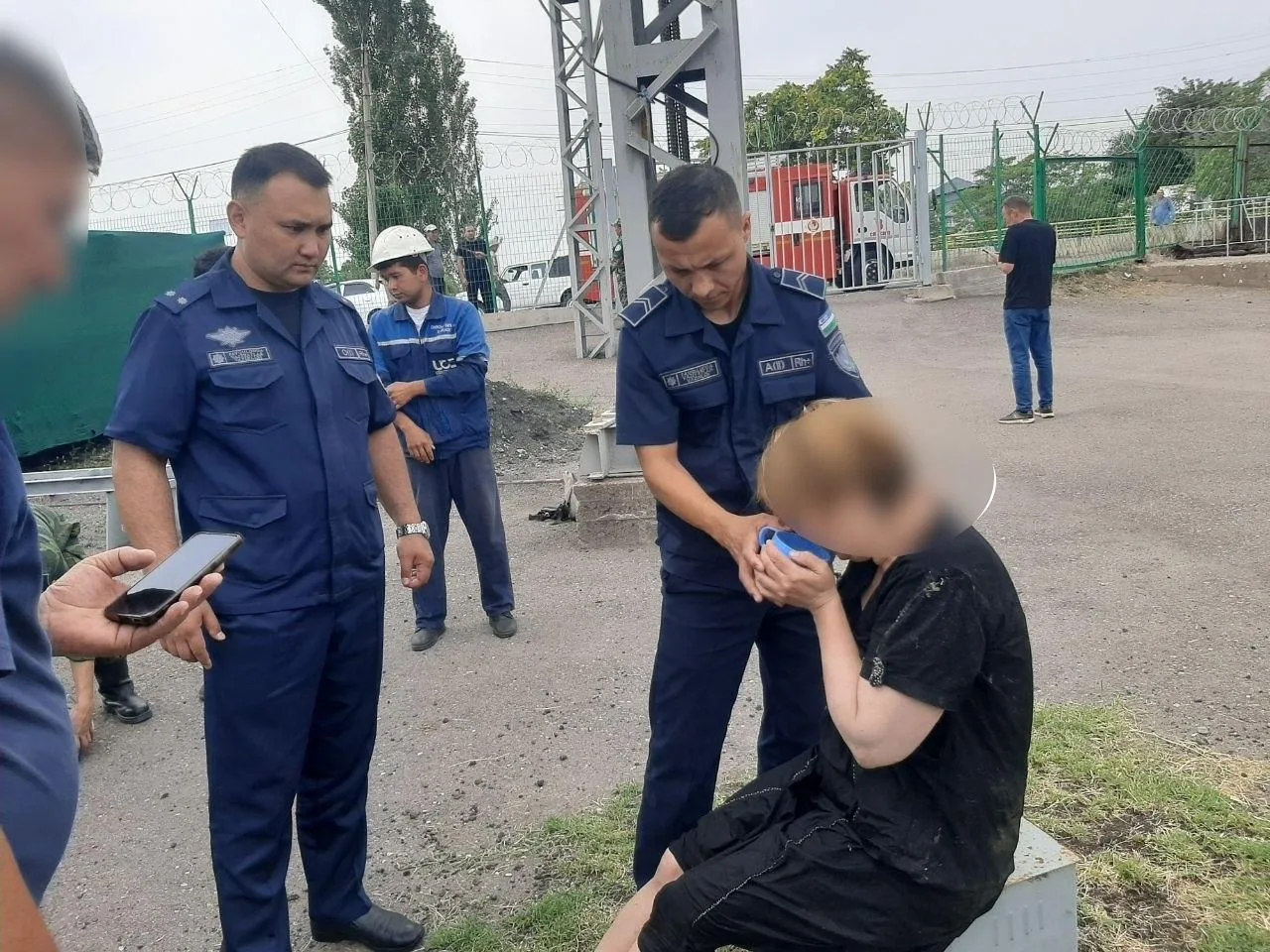Formadagi erkaklar o‘tirgan ayolga yordam bermoqda.