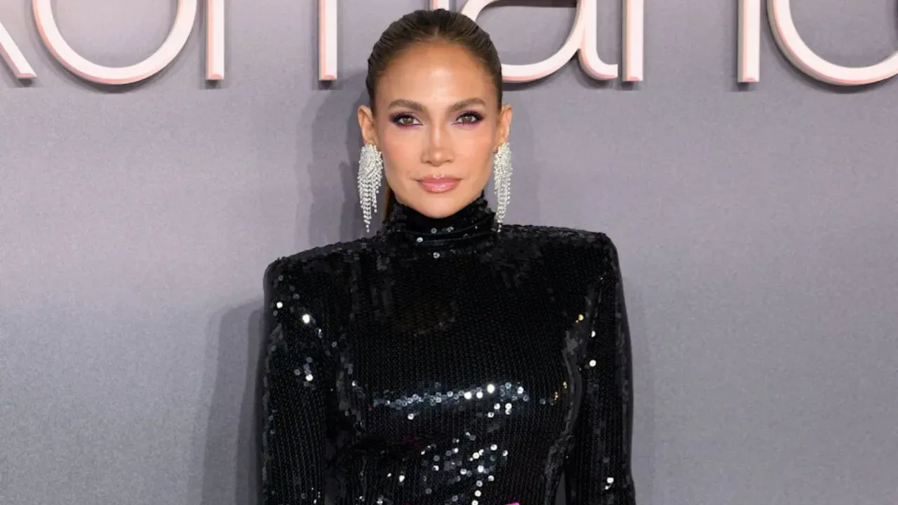 Jennifer Lopez yaltiroq qora ko'ylak va uzun ziraklarda tadbirda turibdi.