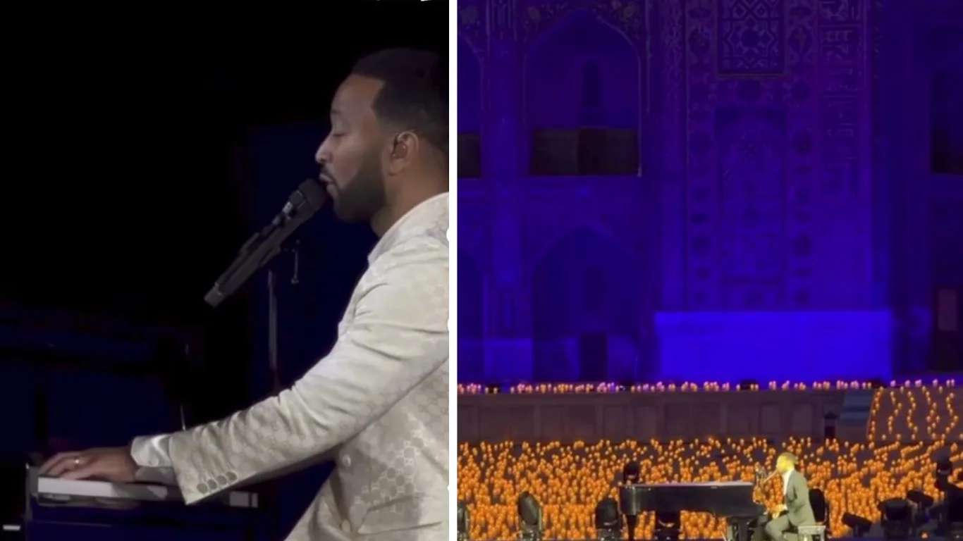 John Legend Registon maydonida ko‘plab shamlar qurshovida pianino chalib kuylamoqda.