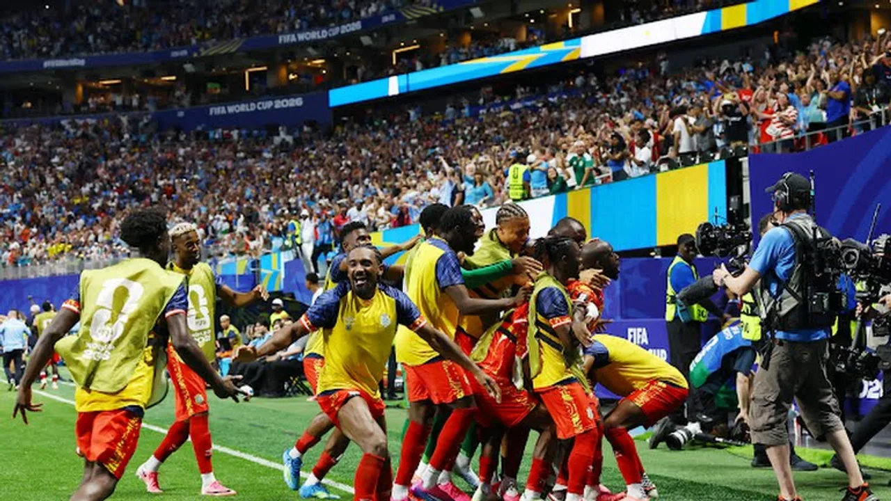 Futbolchilar to‘la stadion o‘rtasida golni quvonch bilan nishonlamoqda.