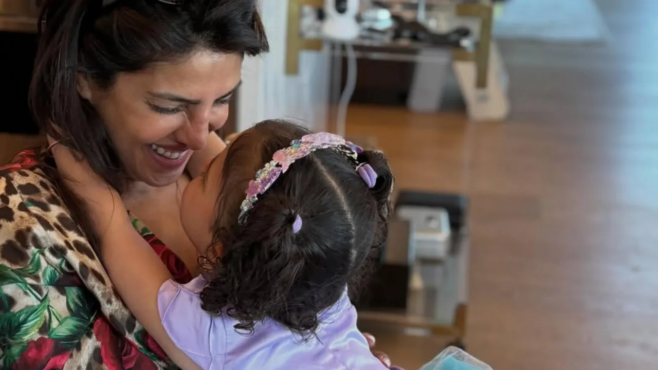 A smiling woman holding a little girl in her arms.