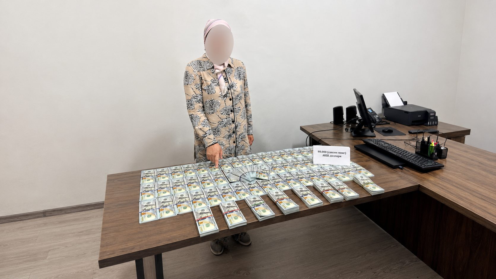 A woman showing a large amount of US dollars on a table.