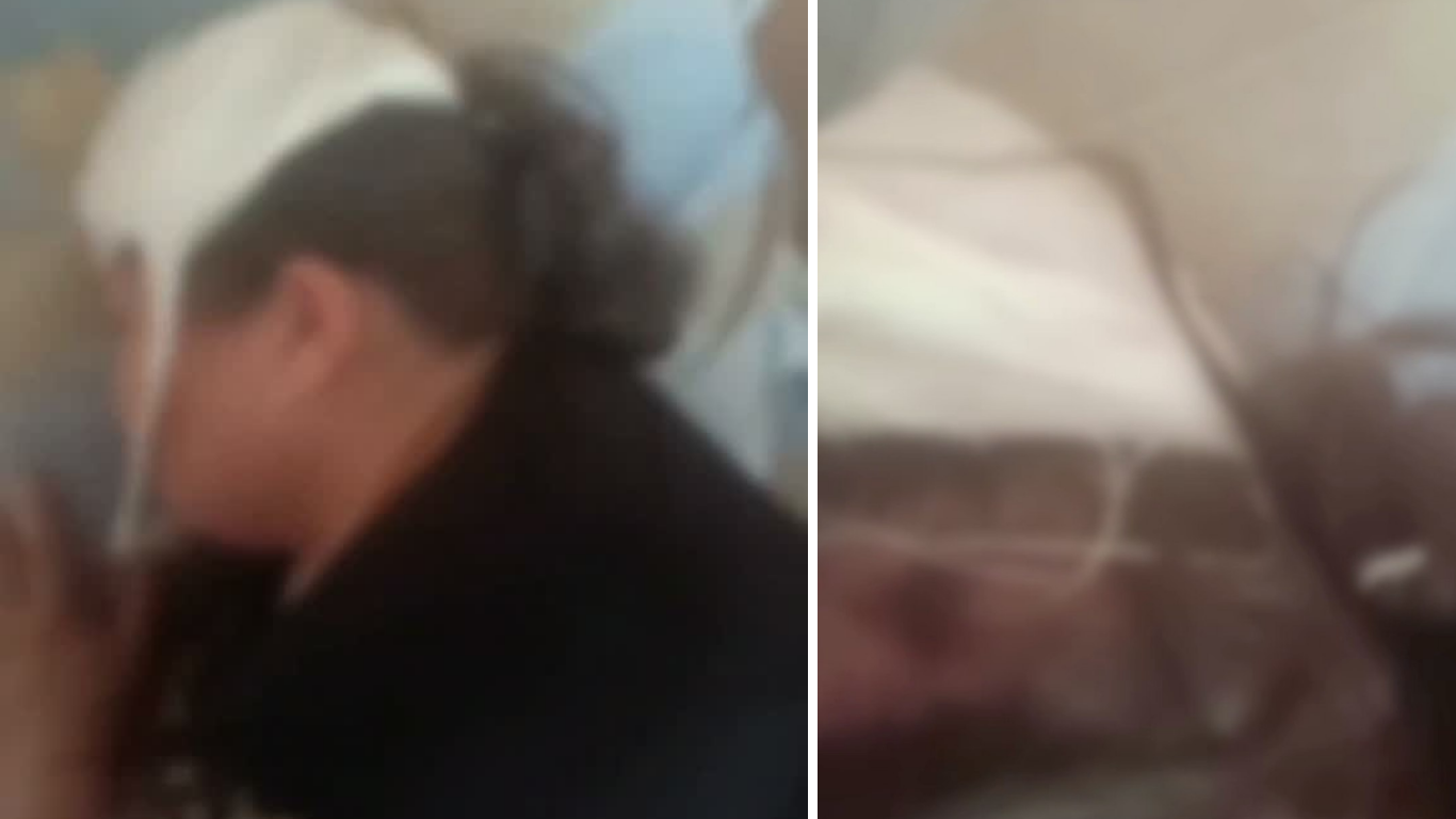 Boshi oq bog'lam bilan o'ralgan, qora kiyimdagi odamning xira tasviri.