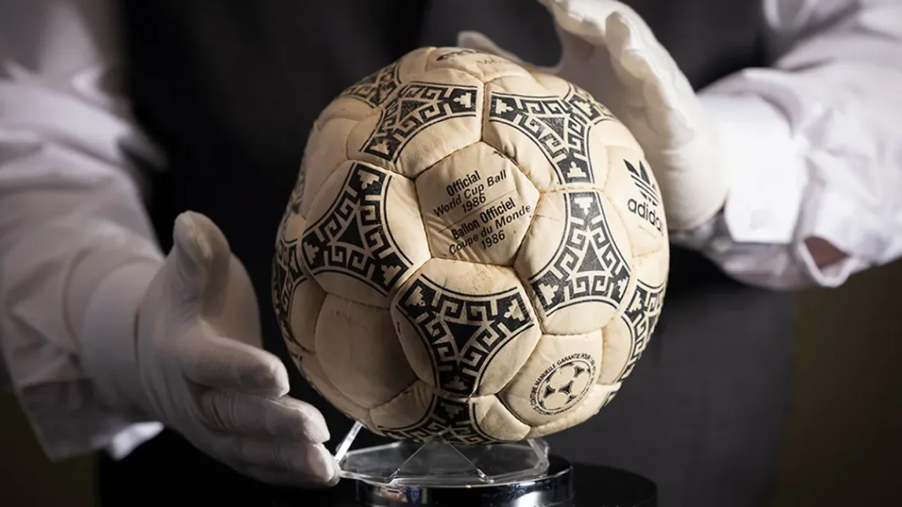 Oq qoʻlqopli odam 1986-yilgi jahon chempionati Adidas Azteca toʻpini ushlab turibdi.