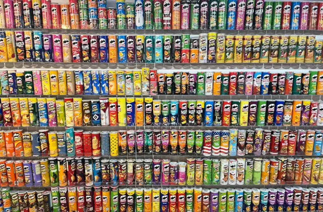 Do'kon peshtaxtasida ko'p sonli turli xil Pringles chiplari qutilari terilgan.
