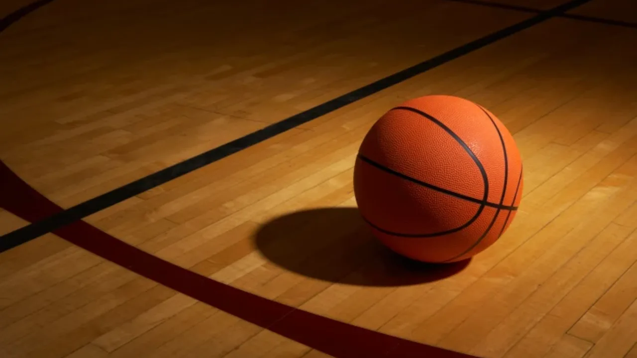 An orange basketball on a wooden basketball court.