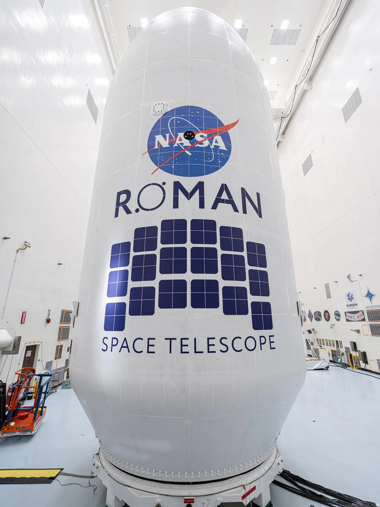 Oq fonda NASA Roman kosmik teleskopining logotipi tushirilgan raketa qobig‘i.