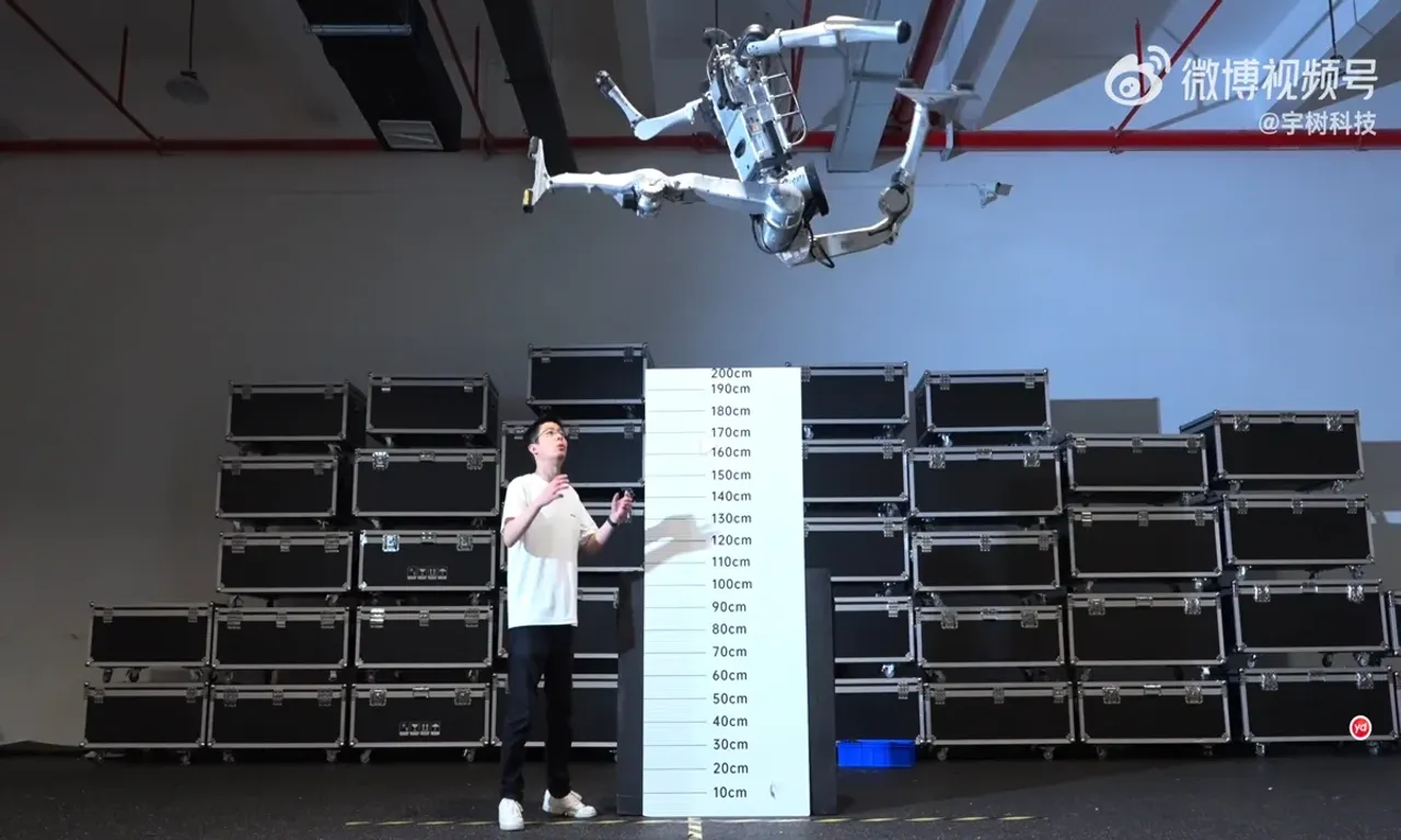 Oq robot odam ustidan balandlik o‘lchagich yonida orqaga salto qilmoqda.