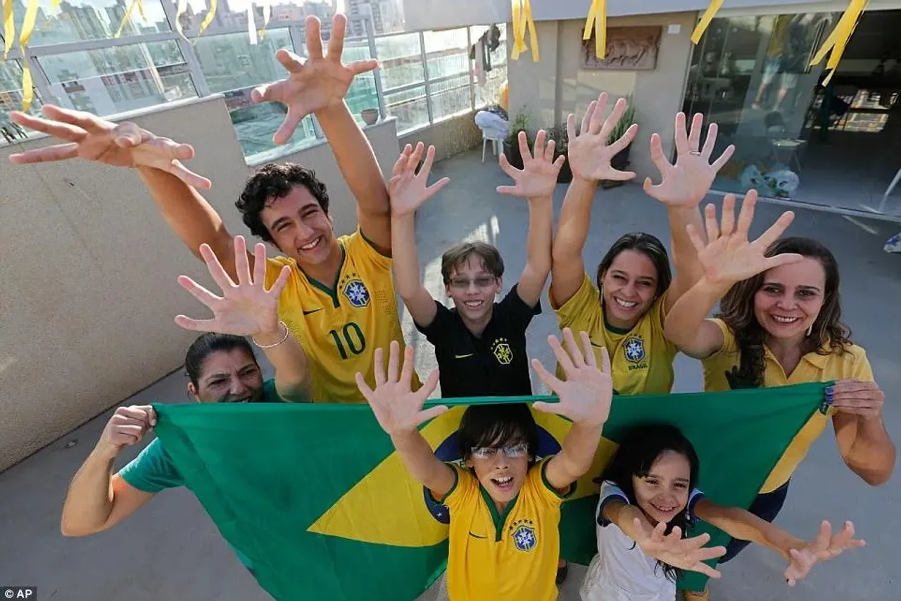 Braziliya bayrog'ini ushlab olti barmoqli qo'llarini ko'rsatayotgan odamlar.