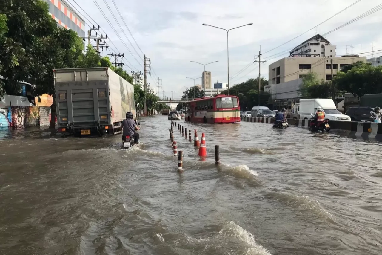 Suv bosgan shahar ko'chasida transport vositalari harakatlanmoqda.