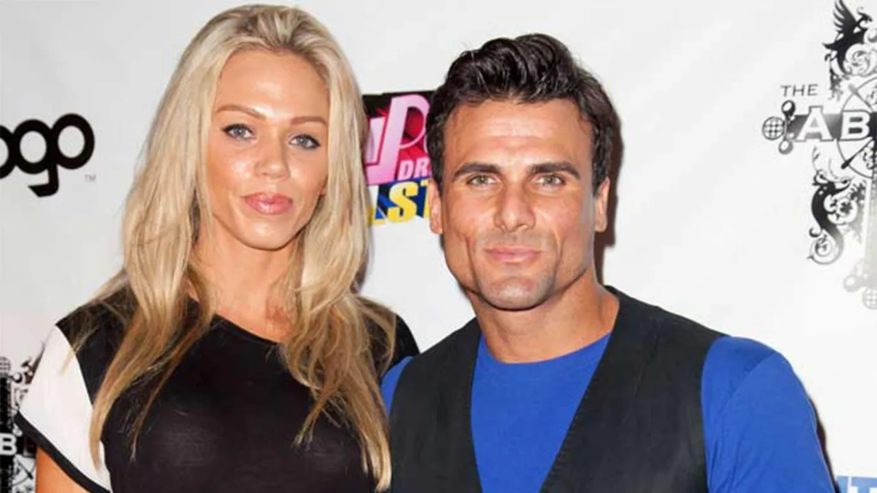 A blonde woman and a dark-haired man standing in front of black and white logos.