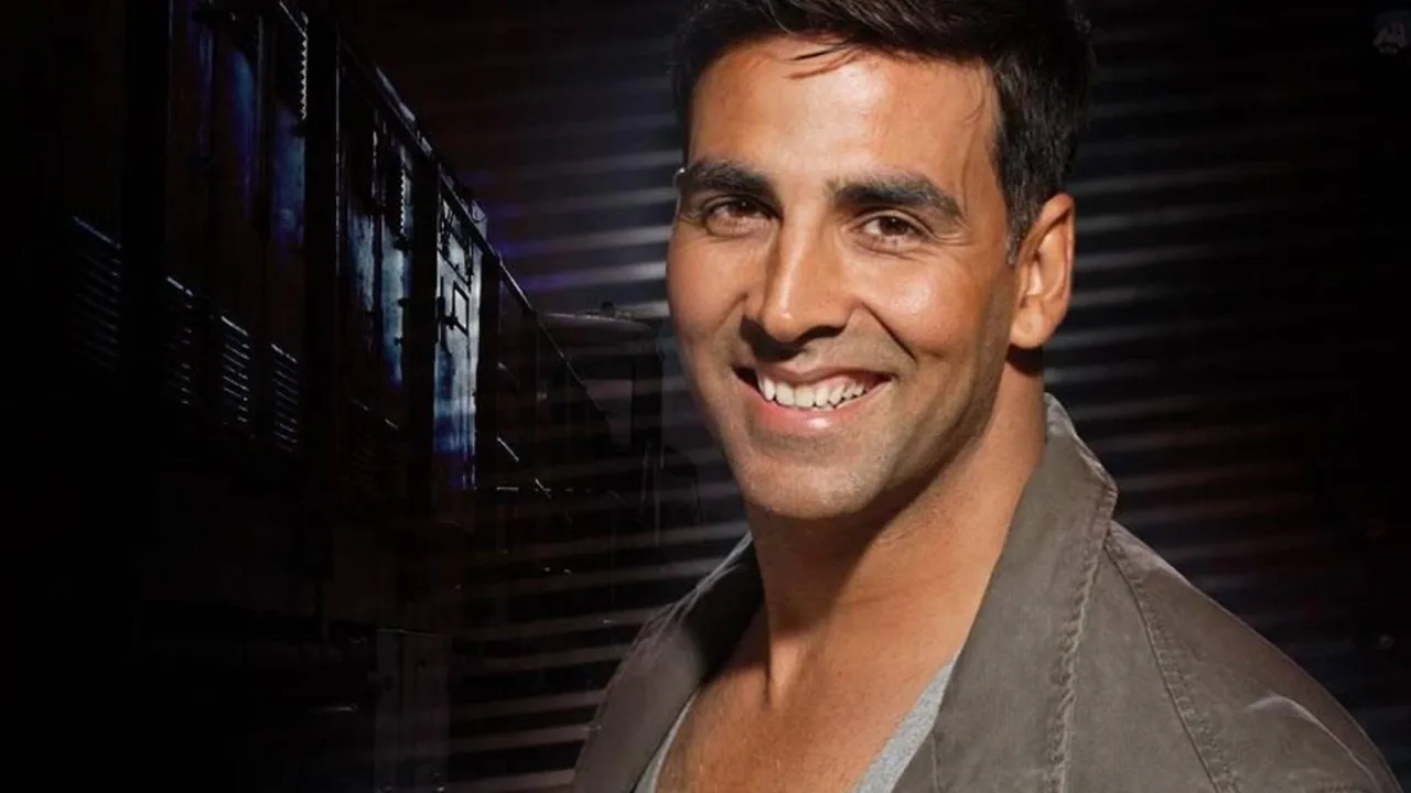 Hind aktyori Akshay Kumar qorong‘i fonda tabassum bilan qarab turibdi.