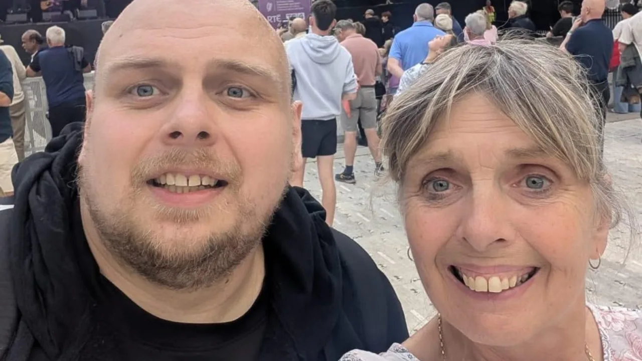 Ochiq havoda tabassum qilib selfi tushayotgan erkak va ayol.