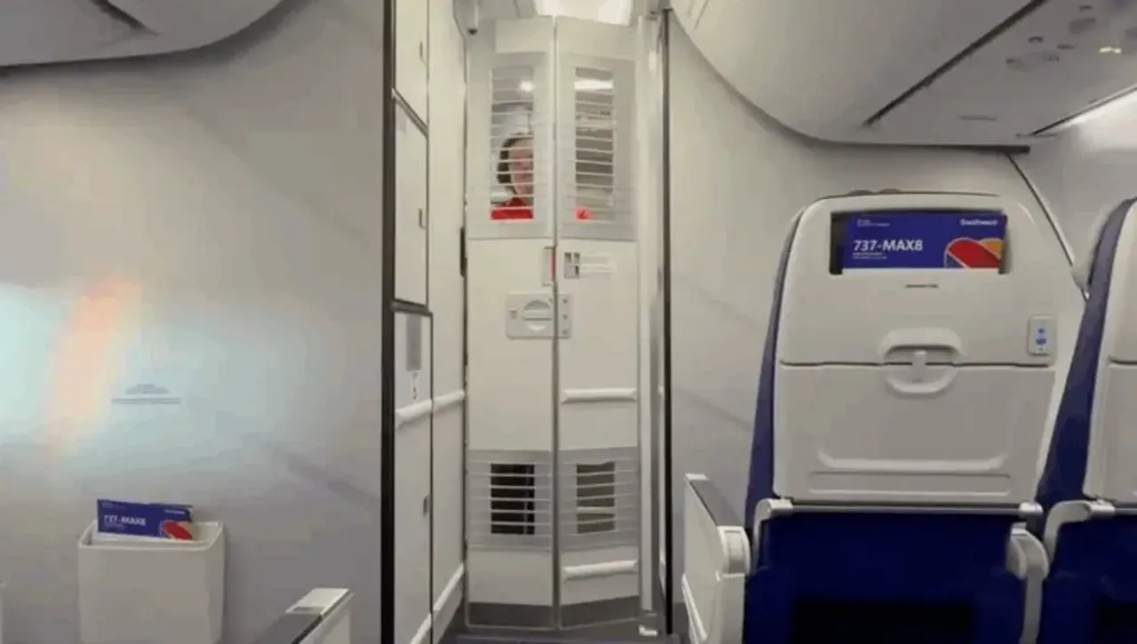 A flight attendant in the airplane cabin and seats of a Boeing 737 MAX 8.