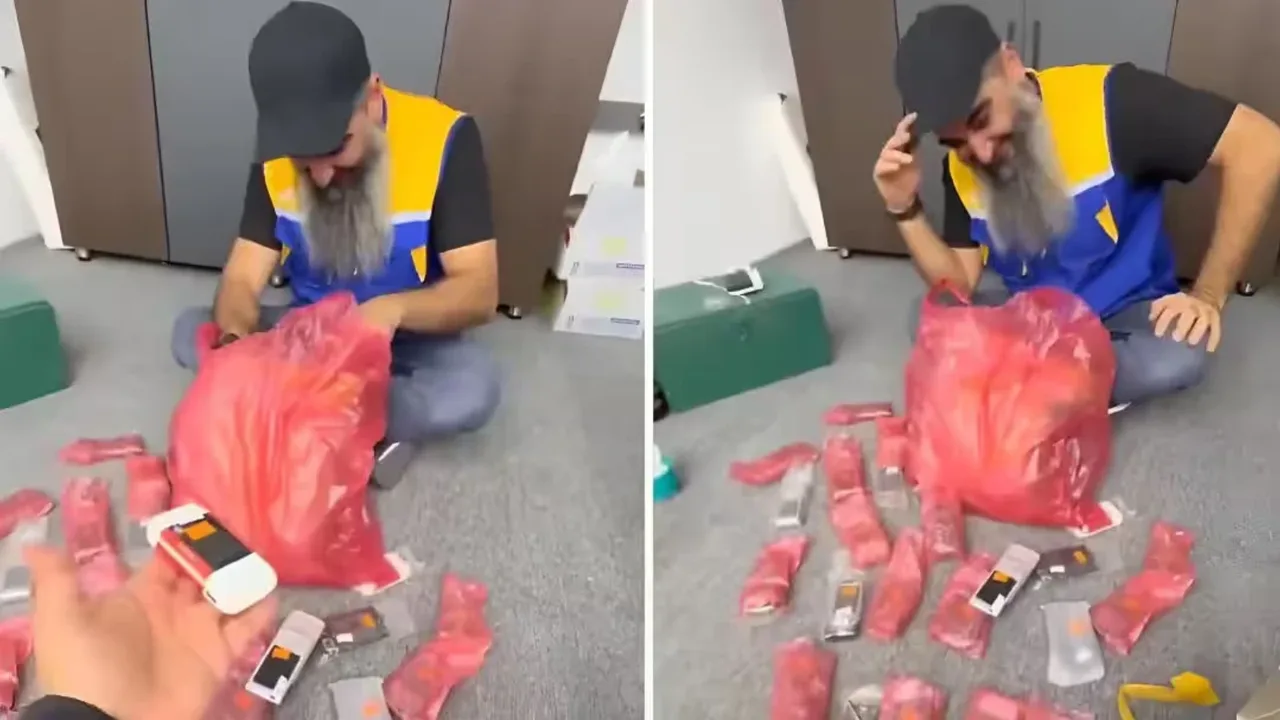 Kiyimdagi kishi qizil paket ichidagi ko‘plab mobil telefonlarni ko‘zdan kechirmoqda.