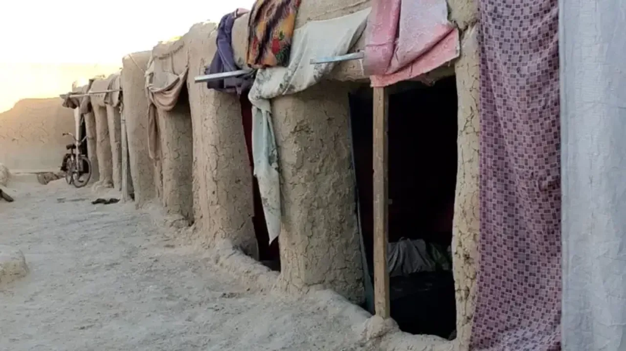 Eshiklari matolar bilan to‘silgan qadimiy loydan yasalgan uylar qatori.