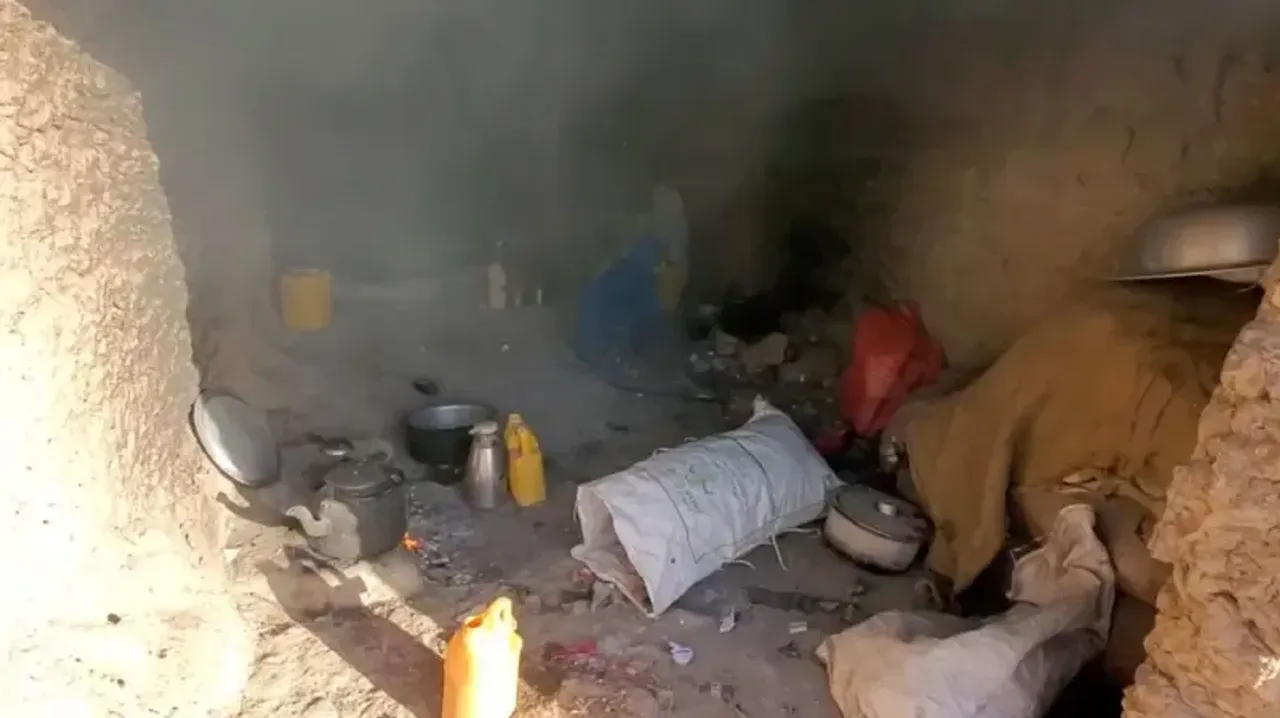 Loy va toshli g‘orda turli xil ro‘zg‘or buyumlari va qoplar tutun ichida yotibdi.