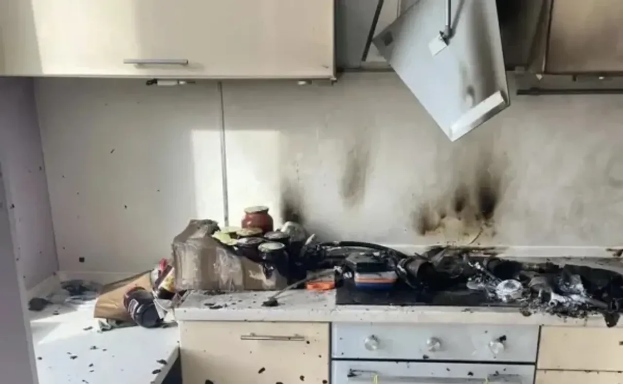 Yonib ketgan oshxona jihozlari va qora kuyindi izlari tushgan devor.